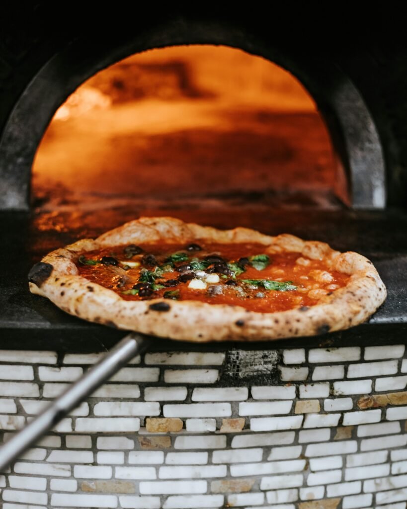pexels-photo-13946695-13946695 Freshly baked Neapolitan pizza emerging from a wood-fired oven in Naples.